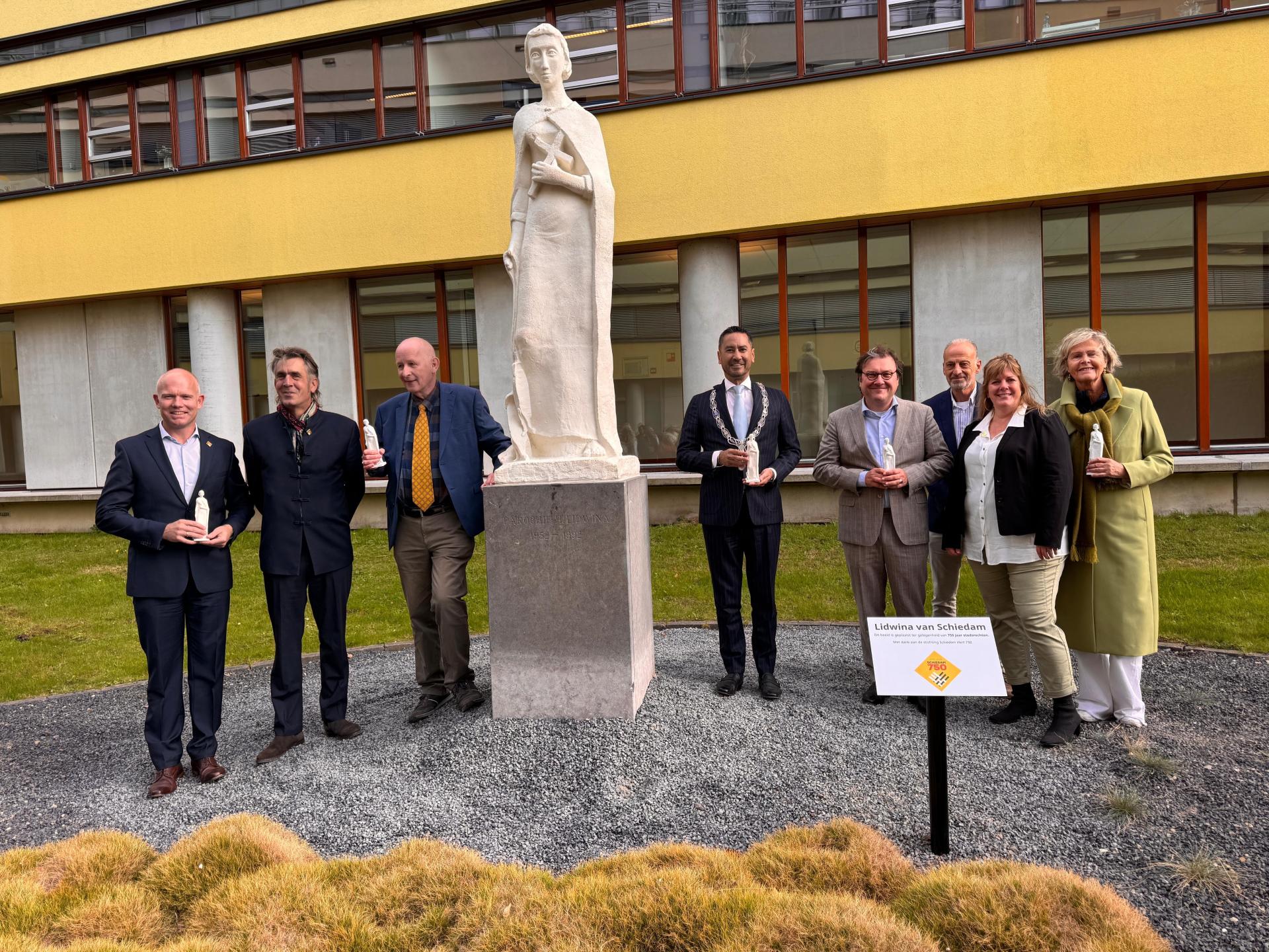 Onthulling beeld Lidwina door burgemeester Bergmann, Jan de Vos en Ernst van Velzen.
